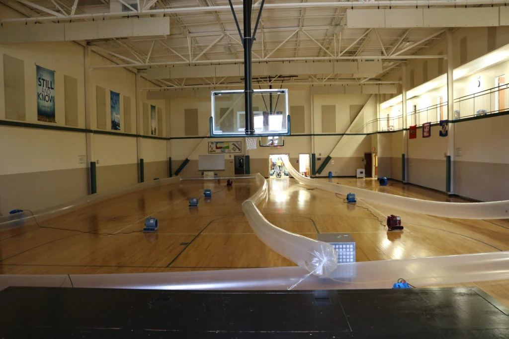 School gymnasium hardwood floor water damage drying with air movers and dehumidifiers