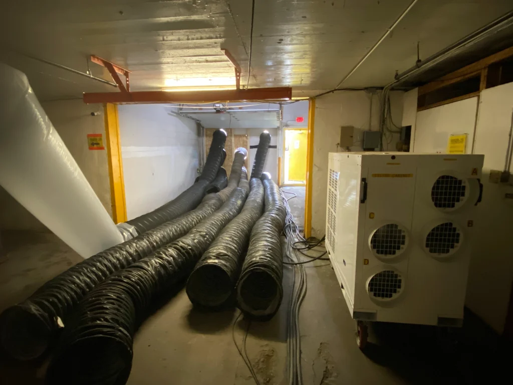 Industrial warehouse structural drying with desiccants, temporary heat, and air movement
